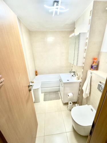 a bathroom with a white toilet and a sink at Medias Apartament in Mediaş