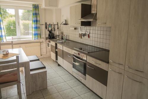 a kitchen with stainless steel appliances and a table at Haffgeflüster Roggow in Rerik