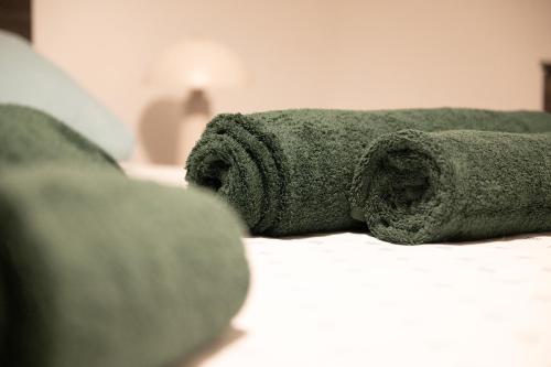 a green towel laying on top of a bed at Marina Di Valletta View Apartment in Tal-Pietà