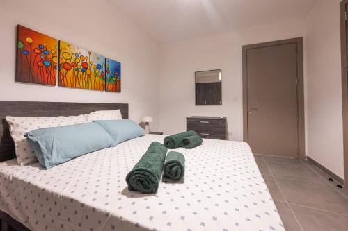 a bedroom with a large bed with towels on it at Marina Di Valletta View Apartment in Tal-Pietà