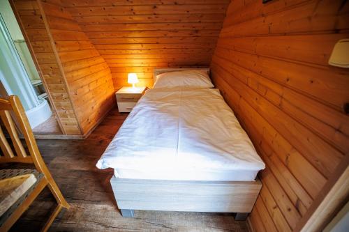 a bedroom with a bed in a wooden room at Chata 70 Dřevěnka Prkenný Důl, Žacléř, Krkonoše in Žacléř