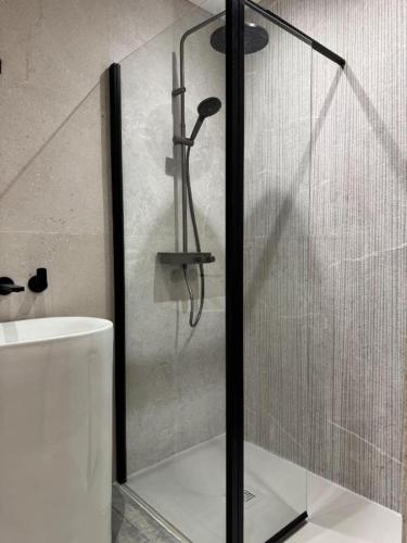 a glass shower in a bathroom with a sink at Il Clovio - Discreet luxury, close to Futuroscope in Jaunay-Marigny