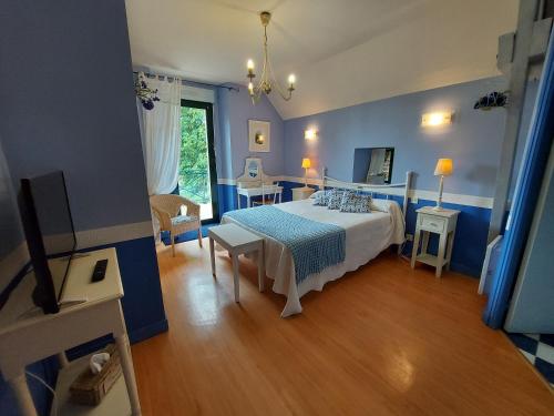 Fleurs des Champs في Saint-Germain-le-Fouilloux: غرفة نوم زرقاء مع سرير وطاولة