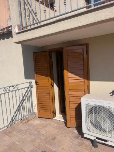 a building with two wooden doors and a fan at L'antico Orologio in Isola Capo Rizzuto