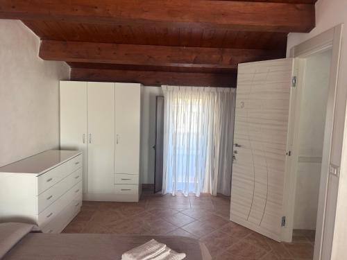 a kitchen with white cabinets and a wooden ceiling at L'antico Orologio in Isola Capo Rizzuto
