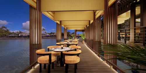 a row of tables and chairs on a balcony with water at Four Seasons Resort Mauritius at Anahita in Beau Champ