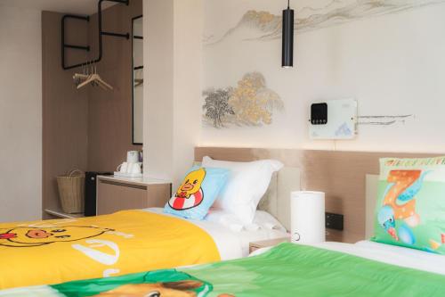 a bedroom with two beds with yellow and green sheets at Shangge Boya Hotel in Shangri-La