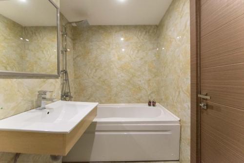 a bathroom with a white tub and a sink at Go-Gudauri The Atrium Residence in Gudauri