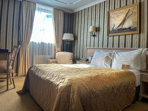 a hotel room with a bed and a chair at Imperial Hotel & Restaurant in Vilnius