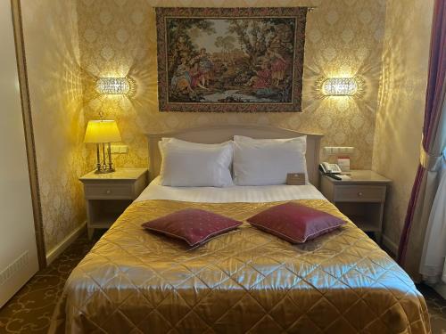 a bedroom with a bed with two pillows on it at Imperial Hotel & Restaurant in Vilnius