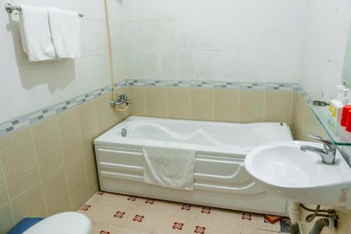 a bathroom with a bath tub and a sink at Kim Thuy Hotel in Can Tho