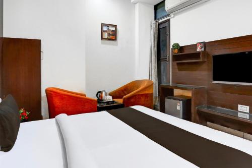 a hotel room with a bed and a flat screen tv at Super Collection O Railway Station Road Near Clock Tower in Ludhiana