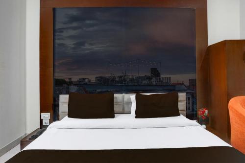 a bedroom with a white bed with a large window at Super Collection O Railway Station Road Near Clock Tower in Ludhiana
