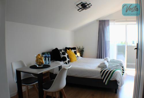 a bedroom with a bed and a table and chairs at VESTA Apartamenty M52 Free parking in Szczecin