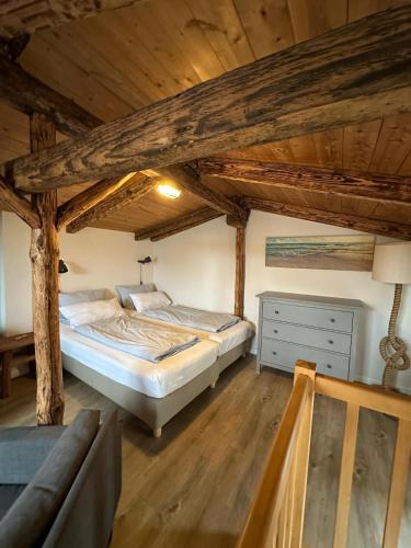 a bedroom with a bed in a room with wooden ceilings at Netzschuppen in Fehmarn