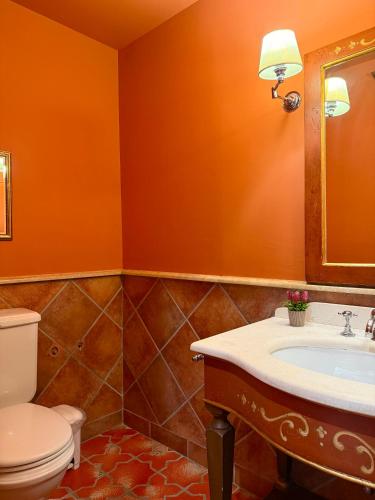 an orange bathroom with a toilet and a sink at Great Greece Le Convivial Suites in Xylokastron