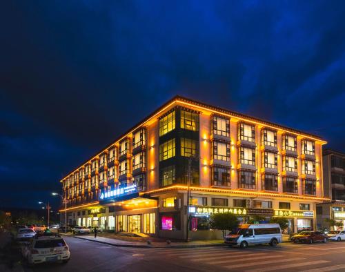 a large building with cars parked in front of it at Shangge Boya Hotel in Shangri-La