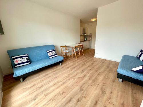 a living room with two blue couches and a table at Bright studio only 320mt from the sea in Porto Santa Margherita di Caorle