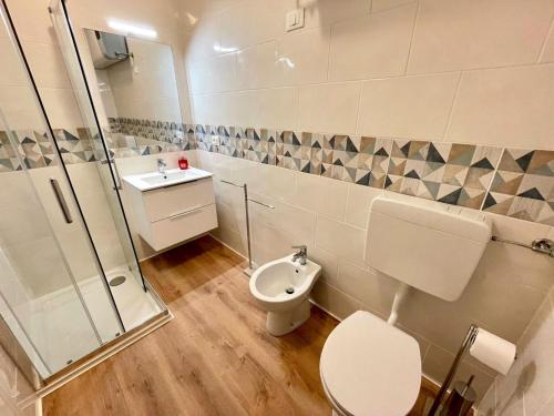 a bathroom with a toilet and a shower and a sink at Bright studio only 320mt from the sea in Porto Santa Margherita di Caorle