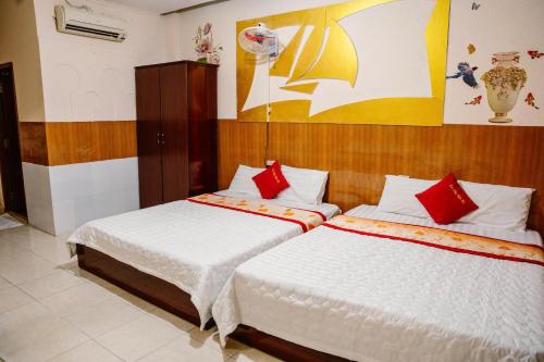 a bedroom with two beds with red pillows at Kim Thuy Hotel in Can Tho