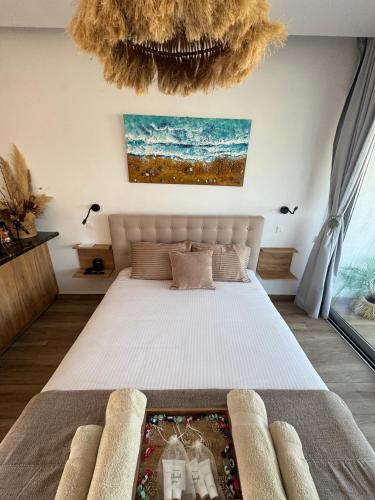 a bedroom with a large bed and a chandelier at Bohemian Rhapsody in Paphos