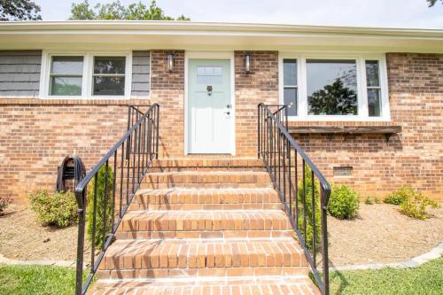 a brick house with stairs leading to a white door at GVL getaway near Paris Mtn, minutes from downtown in Greenville