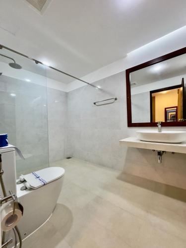 a bathroom with a sink and a toilet and a mirror at Sevonra Beach Resort in Unawatuna