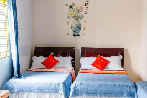two beds in a room with red and blue pillows at Kim Thuy Hotel in Can Tho