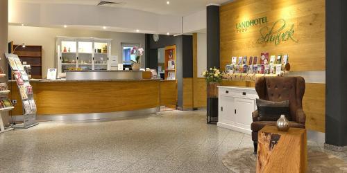 a store with a counter and a chair in a room at Landhotel Schnuck in Schneverdingen