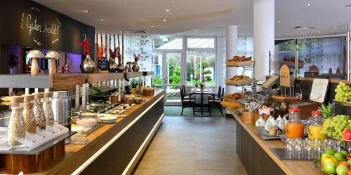 a restaurant with a buffet of food on display at Landhotel Schnuck in Schneverdingen