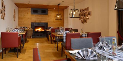 a restaurant with tables and chairs and a fireplace at Landhotel Schnuck in Schneverdingen