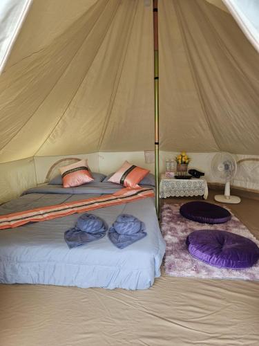 a bed in a tent with two pillows on it at แคมป์ปิ้ง Rose in Pong Yaeng