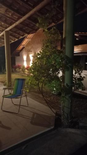 a chair sitting on the side of a patio at CHALE PERTO DA PRAIA COM DUAS SUITES E VARANDAO in Pacatuba