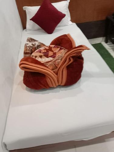a bed with a pile of blankets on it at Hotel Rachna Tourist lodge in New Delhi