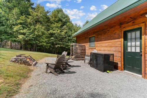 a group of chairs sitting outside of a log cabin at Cozy 3BR Bloff Hytte with Mountain Views and BBQ in Sparta