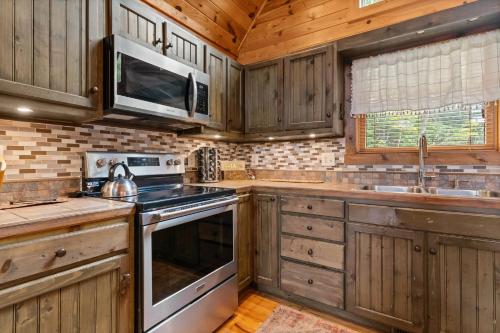 a kitchen with wooden cabinets and a stove top oven at Cozy 3BR Bloff Hytte with Mountain Views and BBQ in Sparta