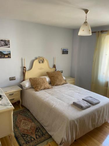 a bedroom with a large bed with two pillows at Casa Rural MONTE ROBLO in Salamón