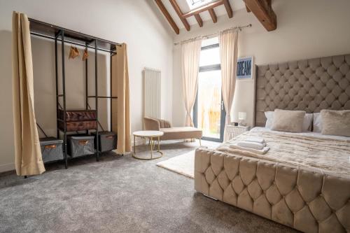 Un dormitorio con una cama grande y una ventana grande. en Rookery Park Barn, en Carlton Colville