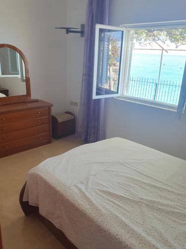 Un dormitorio con una cama y un espejo y una ventana. en Sea View, en Borsh