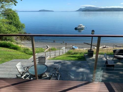 a deck with a view of a boat in the water at Ideal Beachfront Retreat Experience Gorgeous! in Friday Harbor