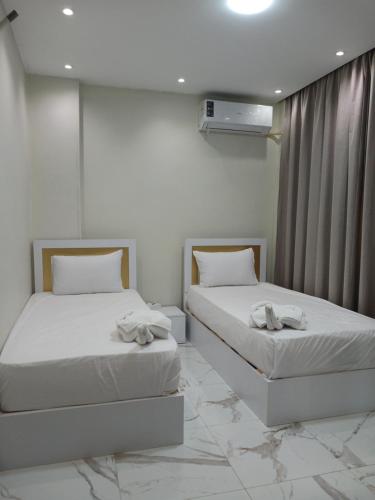 a bedroom with two beds with towels on them at Grand Luxury Apartments - Downtown Cairo in Cairo