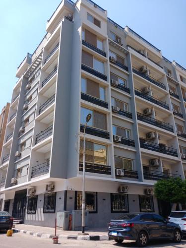 a large white building with cars parked in front of it at Grand Luxury Apartments - Downtown Cairo in Cairo