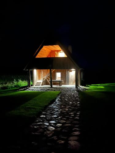 a house lit up at night with a stone path at Lauga Puhkemaja 