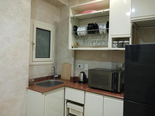 a kitchen with a sink and a microwave at Grand Luxury Apartments - Downtown Cairo in Cairo