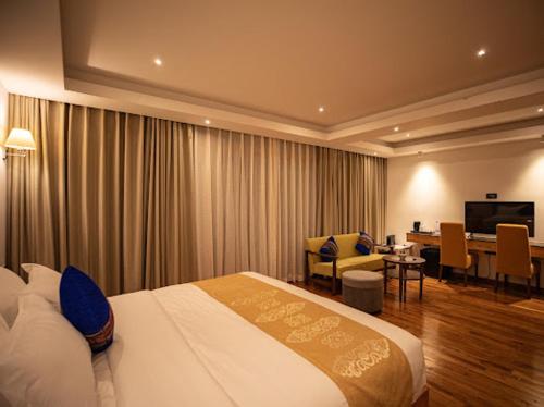 Una habitación de hotel con una cama y un comedor. en Nangter Retreat, en Paro
