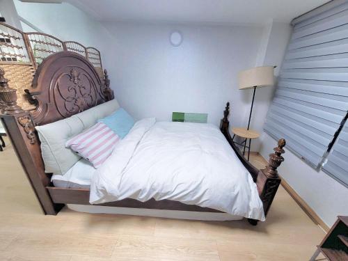 a bedroom with a bed with a wooden headboard at Like U Residence in Goyang