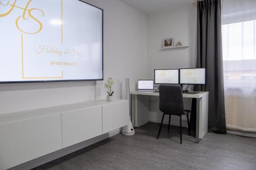 a white office with a desk and a chair at Holiday&Stay, Apartment Relax, Küche, 85Zoll TV, WLAN in Weingarten