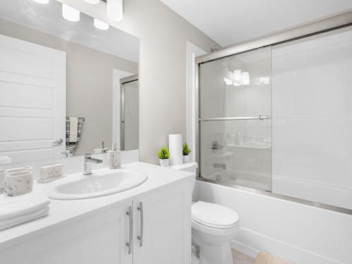 YYCにあるExquisite 1-Bdr Condo Aptの洗面台とトイレを備えた白いバスルーム