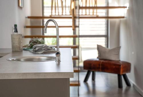 encimera de cocina con fregadero y silla en Ferienhaus "Gartenhaus mit Dachterrasse", en Burg auf Fehmarn