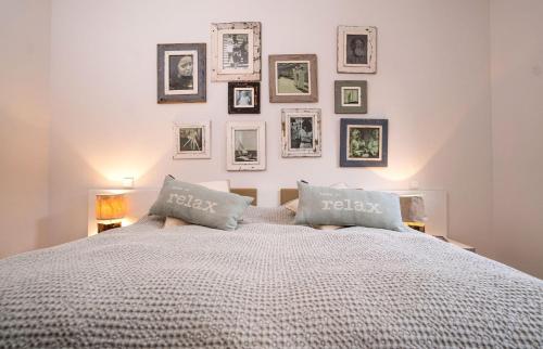 1 dormitorio con 1 cama con cuadros en la pared en Ferienhaus "Gartenhaus mit Dachterrasse", en Burg auf Fehmarn